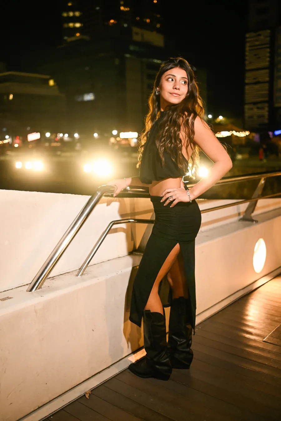 Luana de negro, mirando de costado en una noche de ciudad